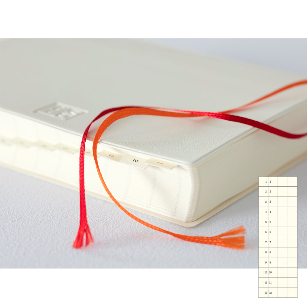 MD Notebook Diary (A5) 1 Day 1 Page 2026 with a minimalist PVC cover, year-stamped spine, and index tabs for each month. The diary is open to show a clean daily page layout on premium MD PAPER, ideal for journaling or planning.