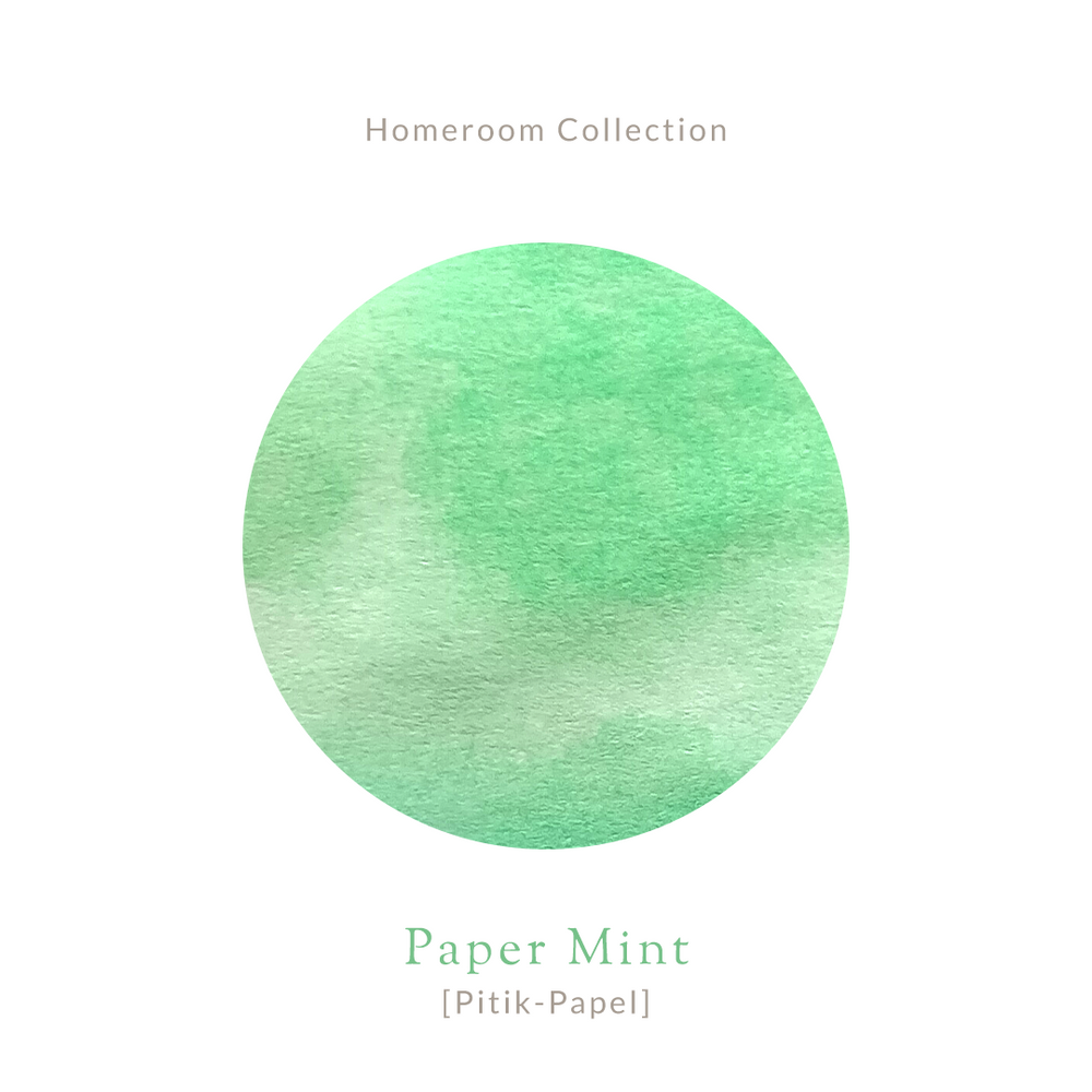 Amber glass bottle of Vinta Inks 30ml in the shade “Paper Mint [Pitik-Papel],” a light mint green ink. The bottle features a charming, nostalgic label and sits next to a swatch of the fresh, playful green ink on white paper.